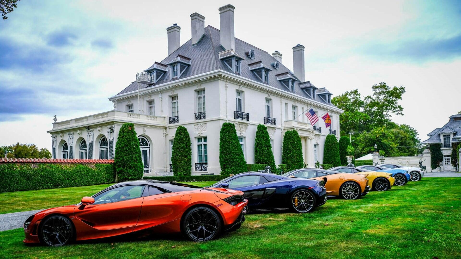 Modern supercars lined up before a Newport mansion